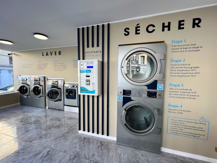 Laverie de Saint Omer 17 A functional laundry room showcasing a row of washing machines and dryers, designed for effective laundry management.